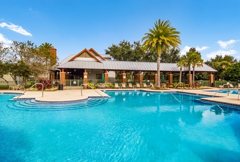 a large swimming pool with a house in the background
